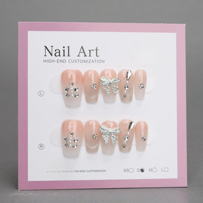 Nail art display with decorative nails on a pink and white card.