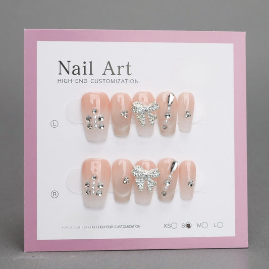 Nail art display with decorative nails on a pink and white card.