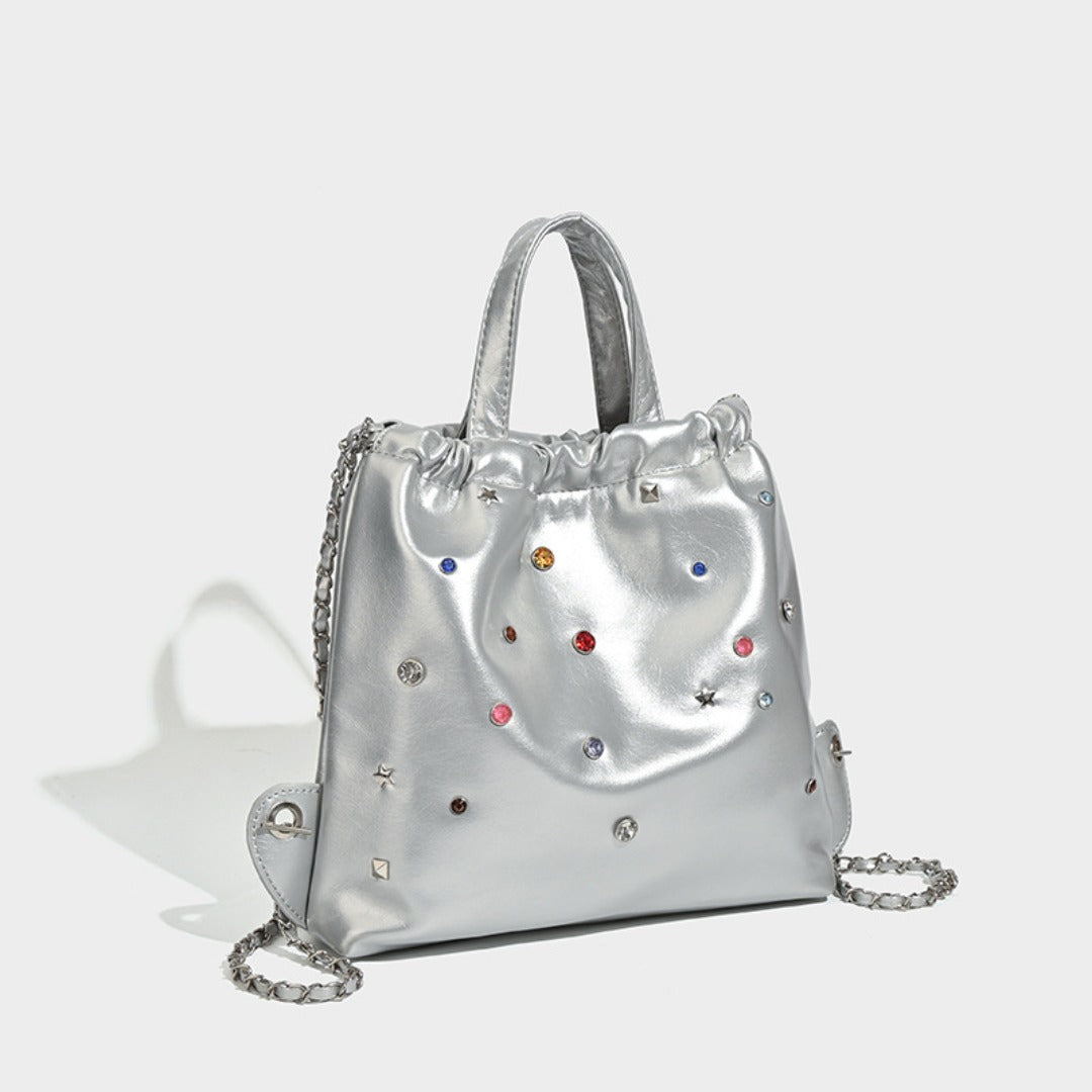 Mochila versátil de gran capacidad, estilo bandolera con cadena y asa de mano. 