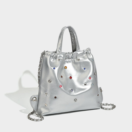 Mochila versátil de gran capacidad, estilo bandolera con cadena y asa de mano. 