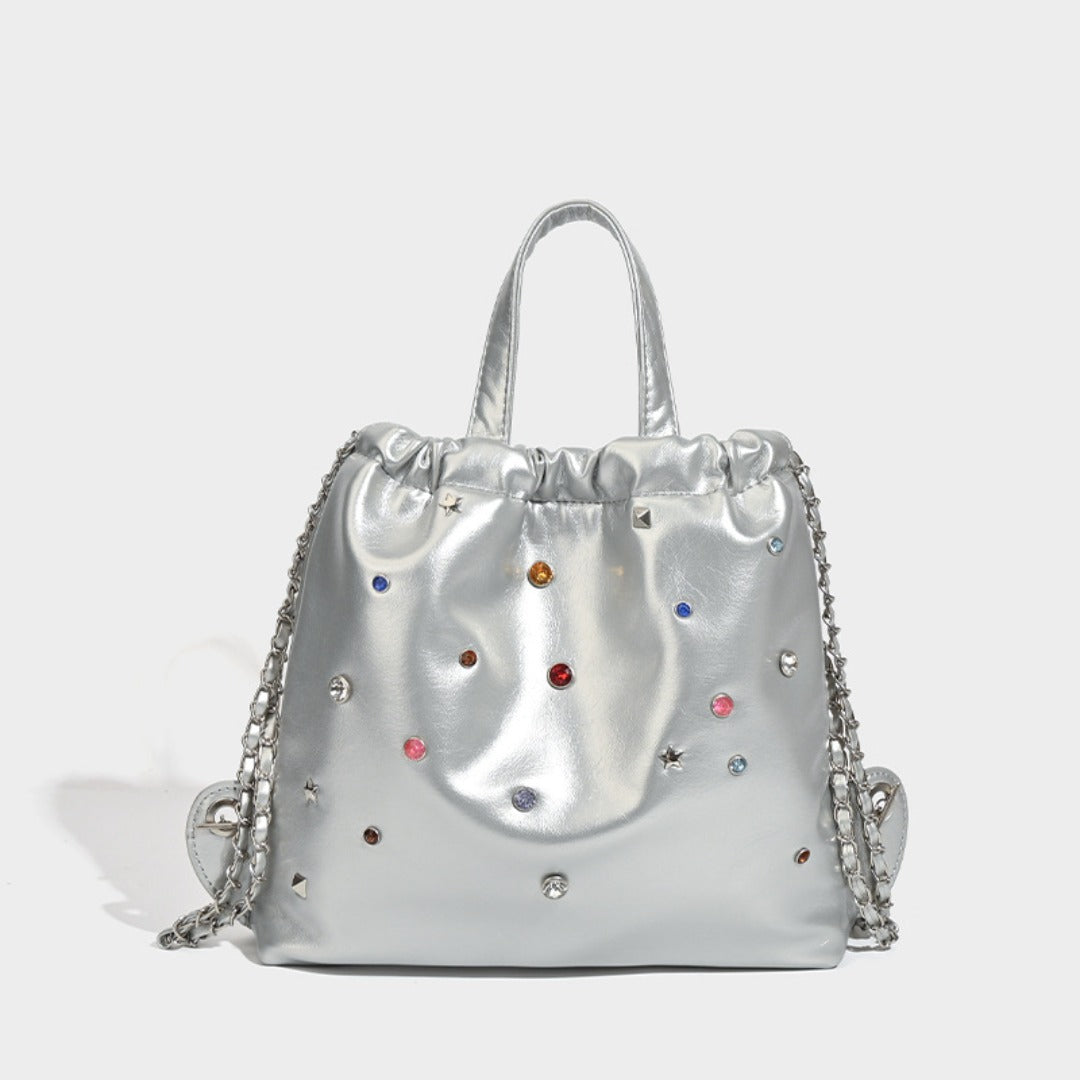 Mochila versátil de gran capacidad, estilo bandolera con cadena y asa de mano. 