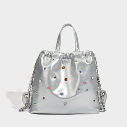 Mochila versátil de gran capacidad, estilo bandolera con cadena y asa de mano. 