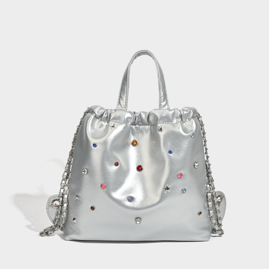 Mochila versátil de gran capacidad, estilo bandolera con cadena y asa de mano. 