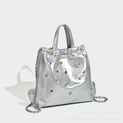 Mochila versátil de gran capacidad, estilo bandolera con cadena y asa de mano. 