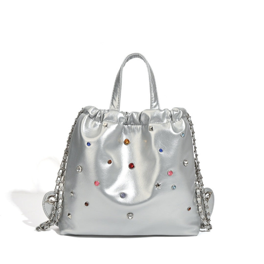 Mochila versátil de gran capacidad, estilo bandolera con cadena y asa de mano. 