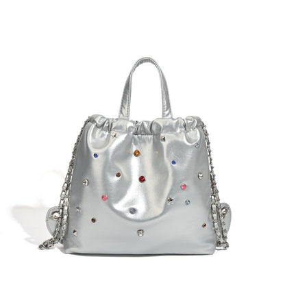 Mochila versátil de gran capacidad, estilo bandolera con cadena y asa de mano. 