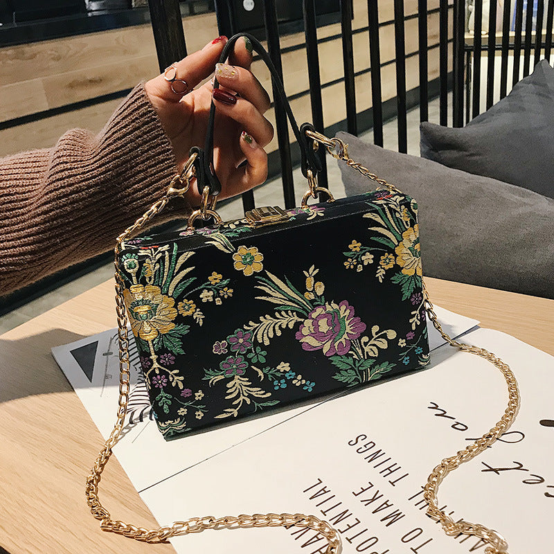 Bolso de mano tipo clutch con estampado floral, ideal para bodas y eventos especiales. Elegante diseño en tonos antiguos. 