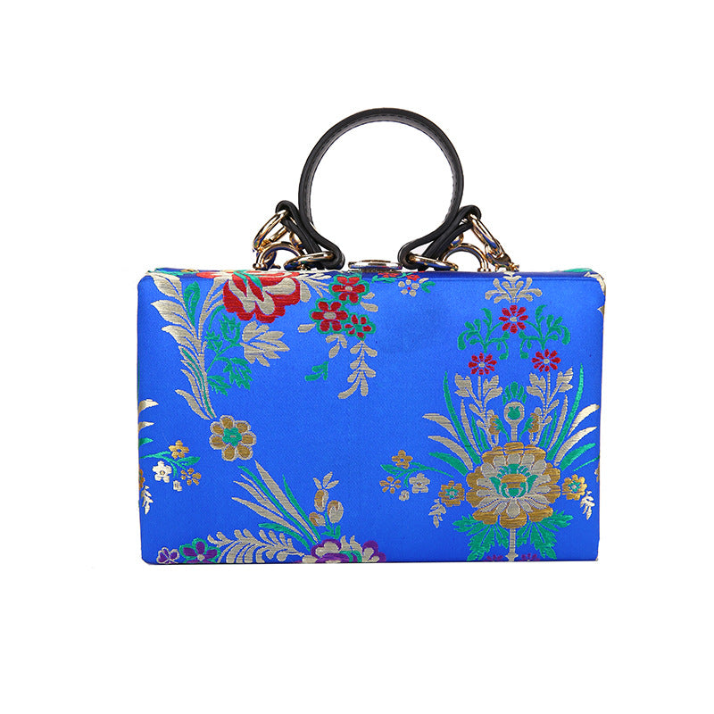 Bolso de mano tipo clutch con estampado floral, ideal para bodas y eventos especiales. Elegante diseño en tonos antiguos. 
