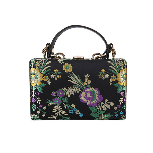 Bolso de mano tipo clutch con estampado floral, ideal para bodas y eventos especiales. Elegante diseño en tonos antiguos. 