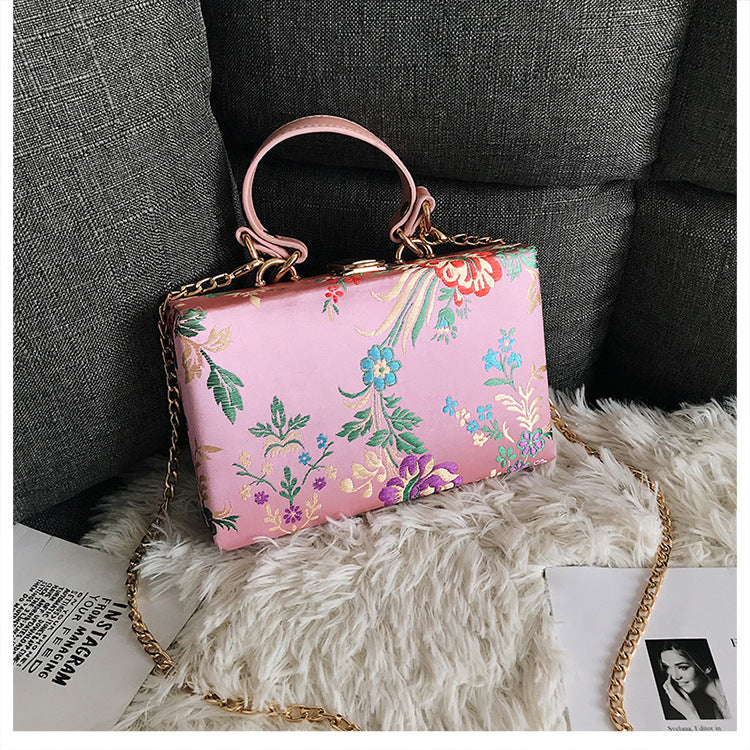 Bolso de mano tipo clutch con estampado floral, ideal para bodas y eventos especiales. Elegante diseño en tonos antiguos. 