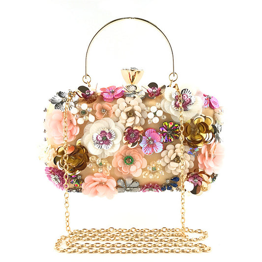 Bolso de mano tipo clutch con estampado floral colorido, ideal para la noche o para ocasiones formales.